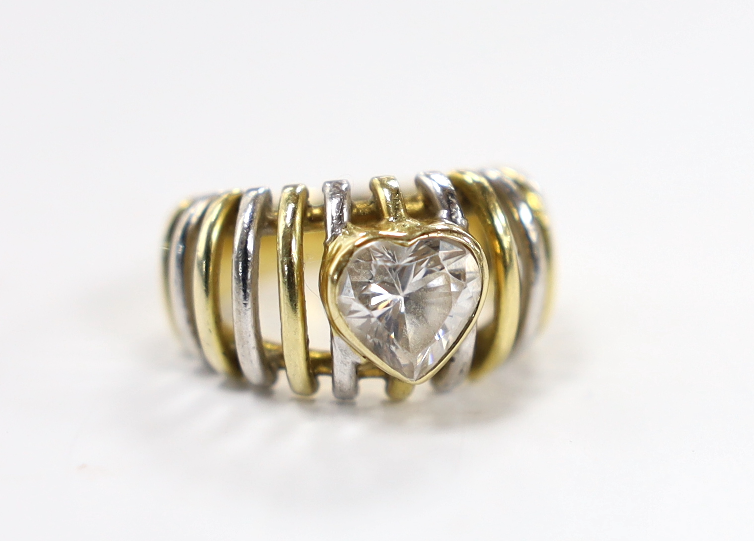 A modern pierced two colour 750 and single stone heart shaped simulated diamond set ring, size K, gross weight 9.4 grams.
